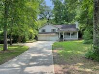 Charming home with a front porch and a large front yard with mature trees at 3840 Whitaker Ln, Lithia Springs, GA 30122