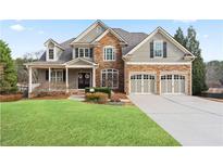 Beautiful two-story home featuring a stone facade, well-manicured lawn, and a two-car garage at 3130 Kates Nw Way, Kennesaw, GA 30152