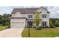 Charming two-story home with a neatly manicured lawn and a three car garage at 7345 Vale Ct, Cumming, GA 30028