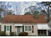 Charming home with a brown roof, green shutters, and a cozy awning, perfect for a starter home at 1785 S Olympian Sw Way, Atlanta, GA 30310