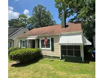 Charming single-story home with green shutters, an American flag, and a covered porch at 1785 S Olympian Sw Way, Atlanta, GA 30310