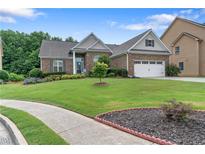 Charming brick home boasts a lush lawn, manicured landscaping and inviting curb appeal at 648 York View Dr, Auburn, GA 30011