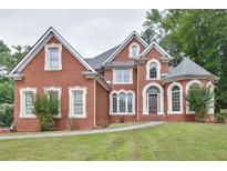 Elegant brick home with manicured lawn, arched windows, and distinctive architectural details at 370 Beracah Sw Trl, Atlanta, GA 30331