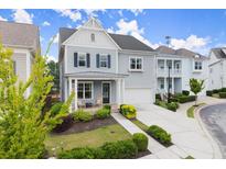 Charming two-story home with a well-manicured lawn, blue siding, and an attached garage on a sunny day at 2075 Parkhaven Ct, Roswell, GA 30076