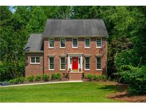 Charming two-story brick home featuring a bright red front door and a well-manicured lawn at 1885 N Creek Cir, Alpharetta, GA 30009