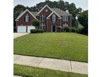 Charming two-story brick home with a well-manicured lawn, attached two-car garage, and a welcoming front entrance at 3381 Walkers Ridge Rd, Dacula, GA 30019