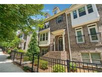 Charming brick townhome featuring multiple stories and a gated front yard with beautiful landscaping at 4012 Townsend Ln, Dunwoody, GA 30346