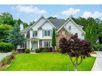 Charming two-story home with stone accents, beautiful landscaping, and a well-manicured lawn at 5963 Wild River Vw, Sugar Hill, GA 30518