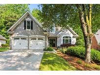Charming stucco home with a two-car garage and beautifully landscaped front yard at 1010 Longcreek Pointe, Alpharetta, GA 30005