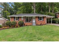 Charming brick home featuring a well-manicured lawn and a convenient carport at 1192 Willivee Dr, Decatur, GA 30033