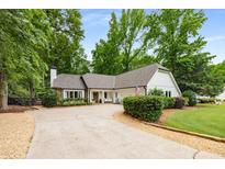 Charming single-story home with well-maintained landscaping and a long driveway at 7114 Surrey Pt, Alpharetta, GA 30009