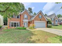 Charming two-story brick home with an attached two-car garage and manicured front lawn at 785 Cirrus Dr, Johns Creek, GA 30022