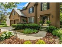 Charming two-story home featuring a well-manicured lawn and inviting entryway with lush landscaping and a two car garage at 3570 Bardfield Ct, Cumming, GA 30041