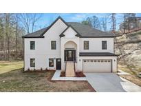 Beautiful two-story home with white brick, black trim, covered entry, and attached two-car garage at 4410 Ross Estates Ct, Snellville, GA 30039