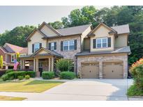 Charming two-story brick home with a well-manicured lawn, two car garage, and inviting front porch at 2525 Well Springs Dr, Buford, GA 30519