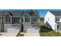 Charming townhome featuring an attached garage and neutral siding in a well-maintained community at 1309 Aura Ln, Lawrenceville, GA 30045