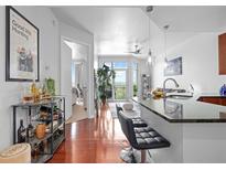 Open-concept kitchen features sleek black countertops, a breakfast bar with stools, and stainless steel appliances at 711 Cosmopolitan Ne Dr # 625, Atlanta, GA 30324