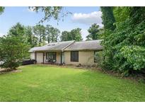 Charming single-story home with lush green lawn, mature trees and landscaping creating great curb appeal at 962 Brighton Dr, Lawrenceville, GA 30043