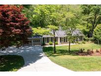 Ranch-style home featuring an attached two-car garage, beautiful landscaping, and a long driveway at 170 Mayfield Cir, Alpharetta, GA 30009