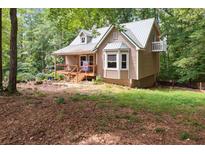 Charming home with a metal roof, inviting porch, and bay window, nestled among lush trees at 141 Mills Creek Path, Hiram, GA 30141