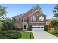 Charming two-story brick home featuring a well-manicured lawn and an attached two-car garage at 10300 Medridge Cir, Johns Creek, GA 30022