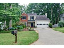 Charming home featuring a well-manicured lawn and lush landscaping at 2212 Mcquiston Sw Dr, Marietta, GA 30064