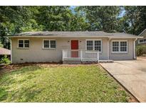 Charming single-story home with a well-manicured lawn and a bright red front door at 2912 Springside Se, Atlanta, GA 30354