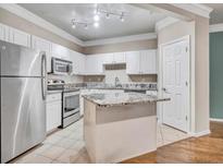 Bright kitchen features white cabinets, granite countertops, stainless steel appliances, and a center island at 1850 Cotillion Dr # 3305, Dunwoody, GA 30338
