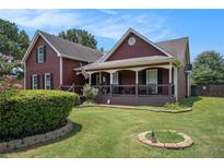 Charming two-story home with a lush green lawn and inviting front porch with American flag at 1951 Chambers Rd, Mcdonough, GA 30253