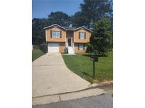 Charming home featuring a well-manicured front yard, a driveway, and a lovely two-story facade at 5653 Bradley Cir, Lithonia, GA 30038