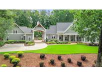 Stately home featuring a portico over the driveway and meticulous landscaping at 114 Trinity Hollow Dr, Canton, GA 30115