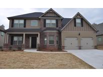 Charming two-story home with a brick and tan exterior, black shutters, and a covered front porch at 1530 Horseshoe Creek Ln, Cumming, GA 30041
