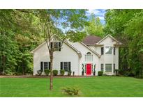 Charming two-story home features a bright red front door and a well-manicured lawn at 76 Barrington Farms Pkwy, Sharpsburg, GA 30277
