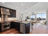 Modern kitchen with stainless steel appliances, dark cabinetry, and an open layout overlooking the living area at 3325 Piedmont Ne Rd # 2104, Atlanta, GA 30305