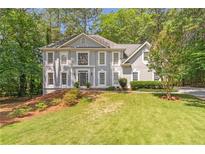 Charming two-story traditional home with a manicured lawn and gray painted brick exterior at 5396 Turnbill Nw Pt, Acworth, GA 30101