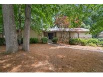 Charming single-story home featuring stone accents and mature trees in a serene setting at 217 Millbrook Farm Rd, Marietta, GA 30068