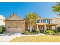 Charming two-story home featuring a stone facade, well-manicured lawn, and attached two car garage at 2235 Well Springs Dr Dr, Buford, GA 30519
