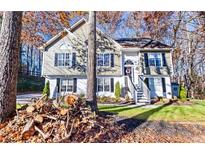 Charming two-story home featuring well-maintained landscaping, neutral siding and black shutters at 126 Laguna Springs Dr, Woodstock, GA 30188