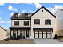 Beautiful two-story home with a modern farmhouse aesthetic, featuring a two car garage, covered entryway, and landscaped yard at 1590 Branthaven Ln, Auburn, GA 30011