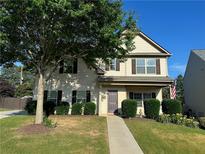 Charming two-story home featuring a well-manicured lawn, mature tree, and classic architectural details at 203 Creek View Ln, Acworth, GA 30102