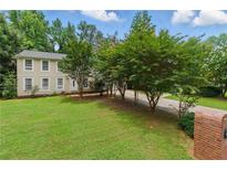 Charming two-story home featuring a well-manicured lawn, mature trees, and a welcoming entrance at 4773 Aberdeen Ln, Stone Mountain, GA 30083
