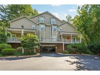Attractive condo building with covered parking, landscaped grounds, and inviting front porches at 4467 Pineridge Cir, Atlanta, GA 30338