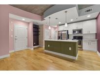 Modern kitchen features an island, stainless steel appliances, and white cabinets at 950 Nw W Peachtree Nw St # 410, Atlanta, GA 30309