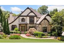 Charming home showcasing a stone and tan exterior with a meticulously landscaped front yard and inviting front entrance at 3770 Riverly Trce, Marietta, GA 30067