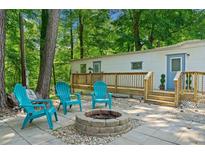 Cozy backyard space with paver patio, fire pit, Adirondack chairs, and a deck on a white home at 1000 Delta Dr, Canton, GA 30114