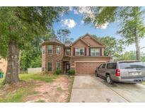 Charming two-story home featuring stone accents and a two-car garage, nestled on a lush lot at 568 Musical Ct, Lawrenceville, GA 30044