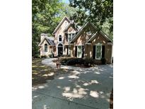 Charming home featuring a curved driveway leading to a traditional facade with meticulously manicured landscaping at 2901 Briscoe Rd, Loganville, GA 30052