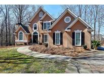 Inviting two-story stucco home featuring well-manicured landscaping and a charming entrance at 2901 Briscoe Rd, Loganville, GA 30052