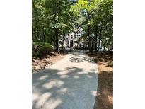 Traditional two-story home boasts a lush green lawn and a long driveway, nestled in a mature wooded setting at 2901 Briscoe Rd, Loganville, GA 30052