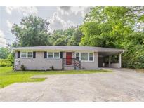 Charming one-story home with red front door, light brick, and attached carport at 2957 Browns Mill Se Rd, Atlanta, GA 30354